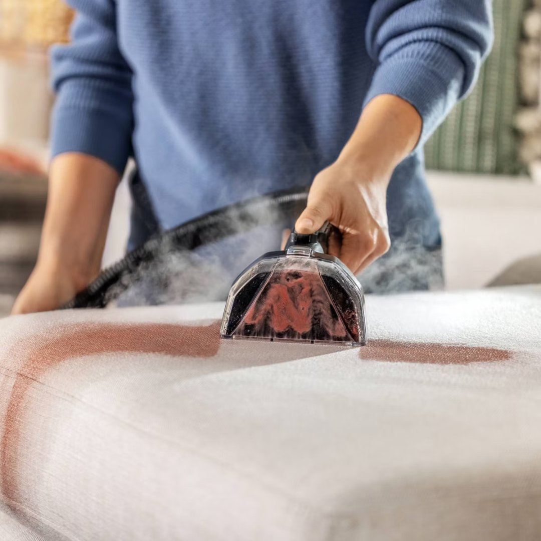 BISSELL Little Green HydroSteam Pet 3605 steam cleaning a stain on a white upholstered cushion