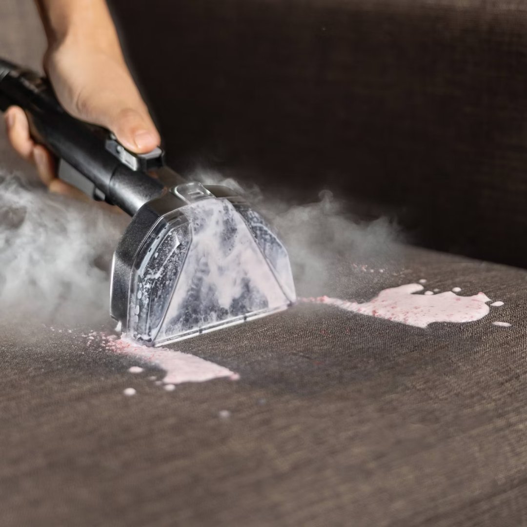 BISSELL Little Green HydroSteam Pet 3605 steam lifting a spill from a dark fabric couch
