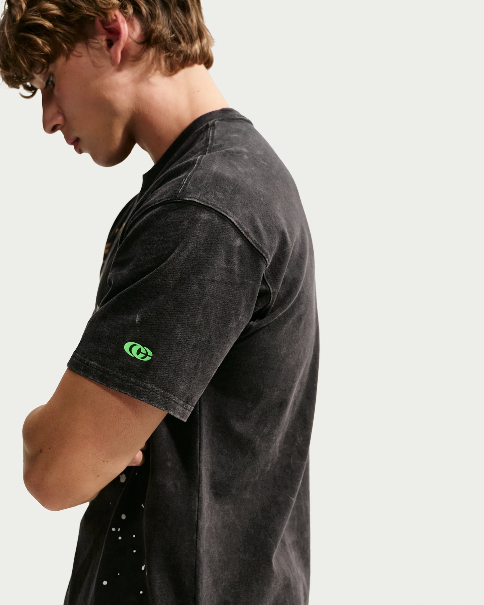 Side view of the Caitlin Clark Halloween tee showing the washed black cotton and green sleeve logo