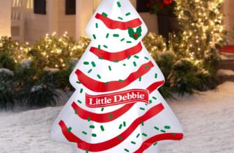 Little Debbie Christmas Tree Cake inflatable lit up in a snowy front yard with holiday lights