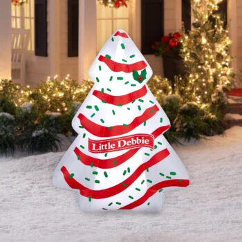 Little Debbie Christmas Tree Cake inflatable lit up in a snowy front yard with holiday lights