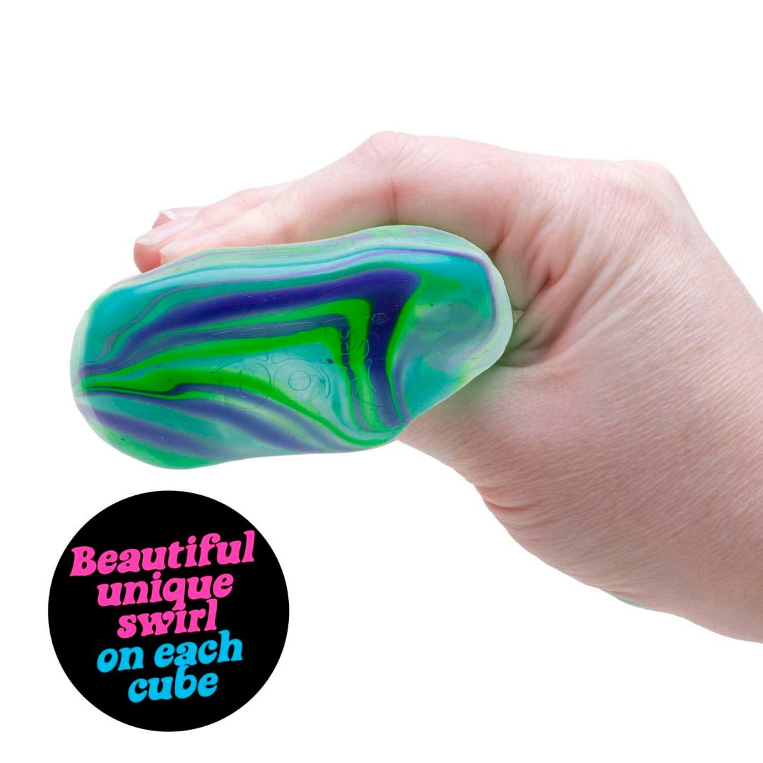 Hand squeezing a green and blue NeeDoh Nice Cube Swirl