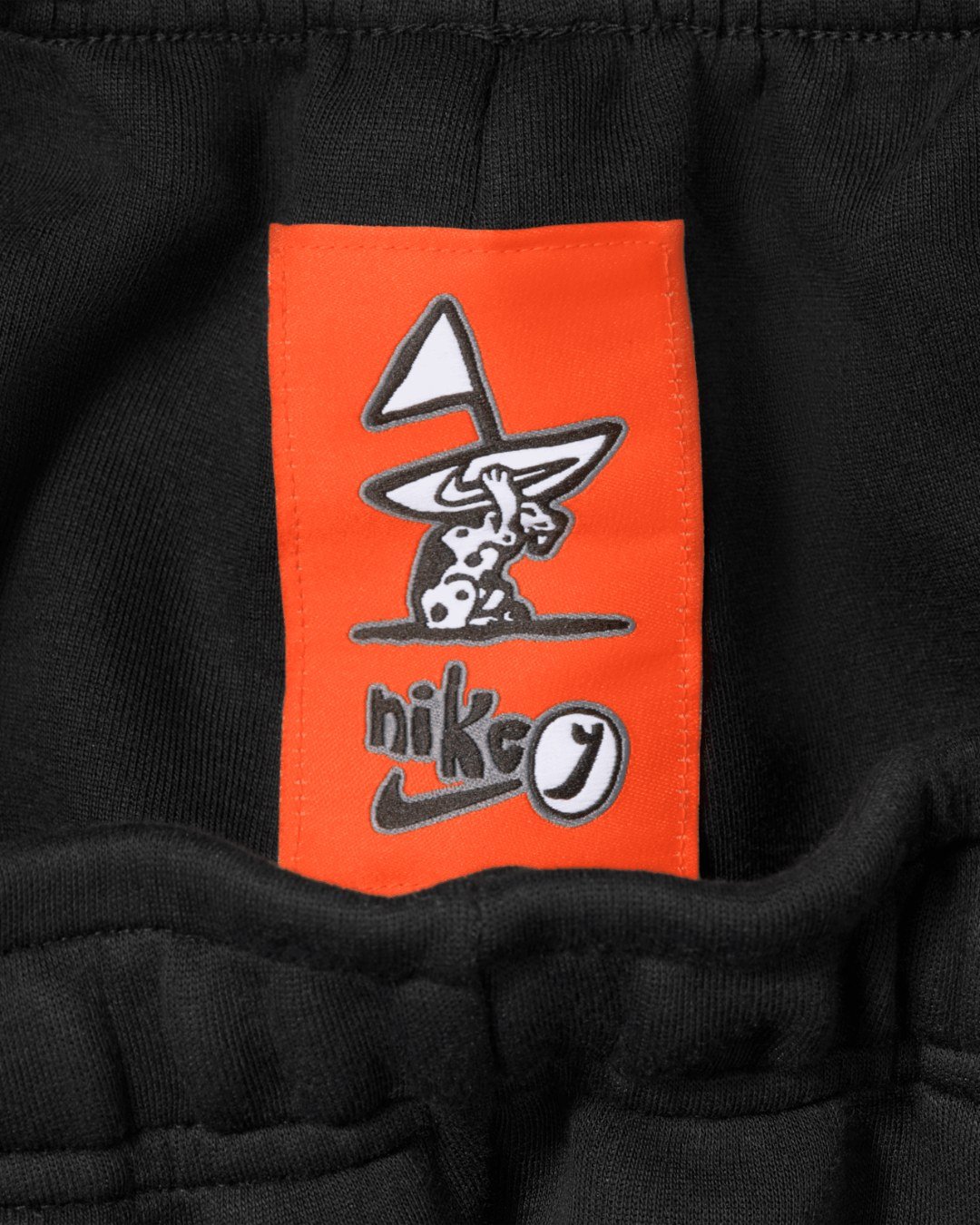Custom orange Lil Yachty label on the Nike Tech fleece shorts