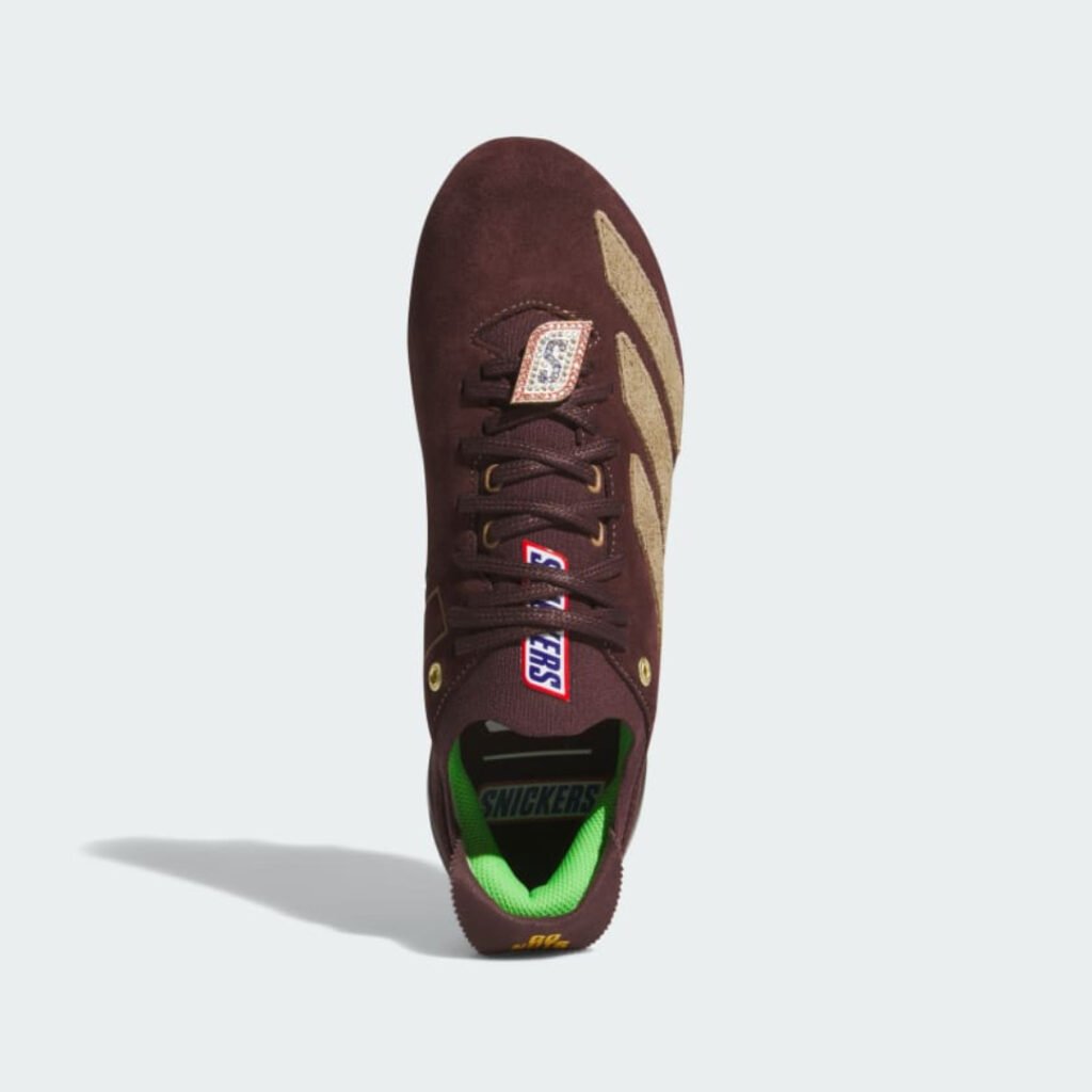 Top view of the Snickers x adidas cleat showing the lace charm and green lining