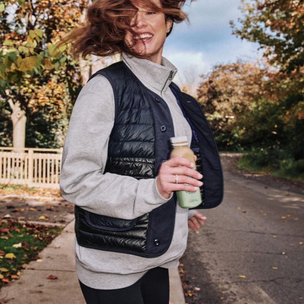Woman walking outdoors holding a Starbucks Coffee and Protein bottle
